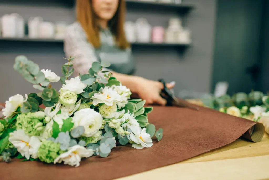 Sharon's Flower Shop florist carefully arranging a custom bouquet for local delivery.